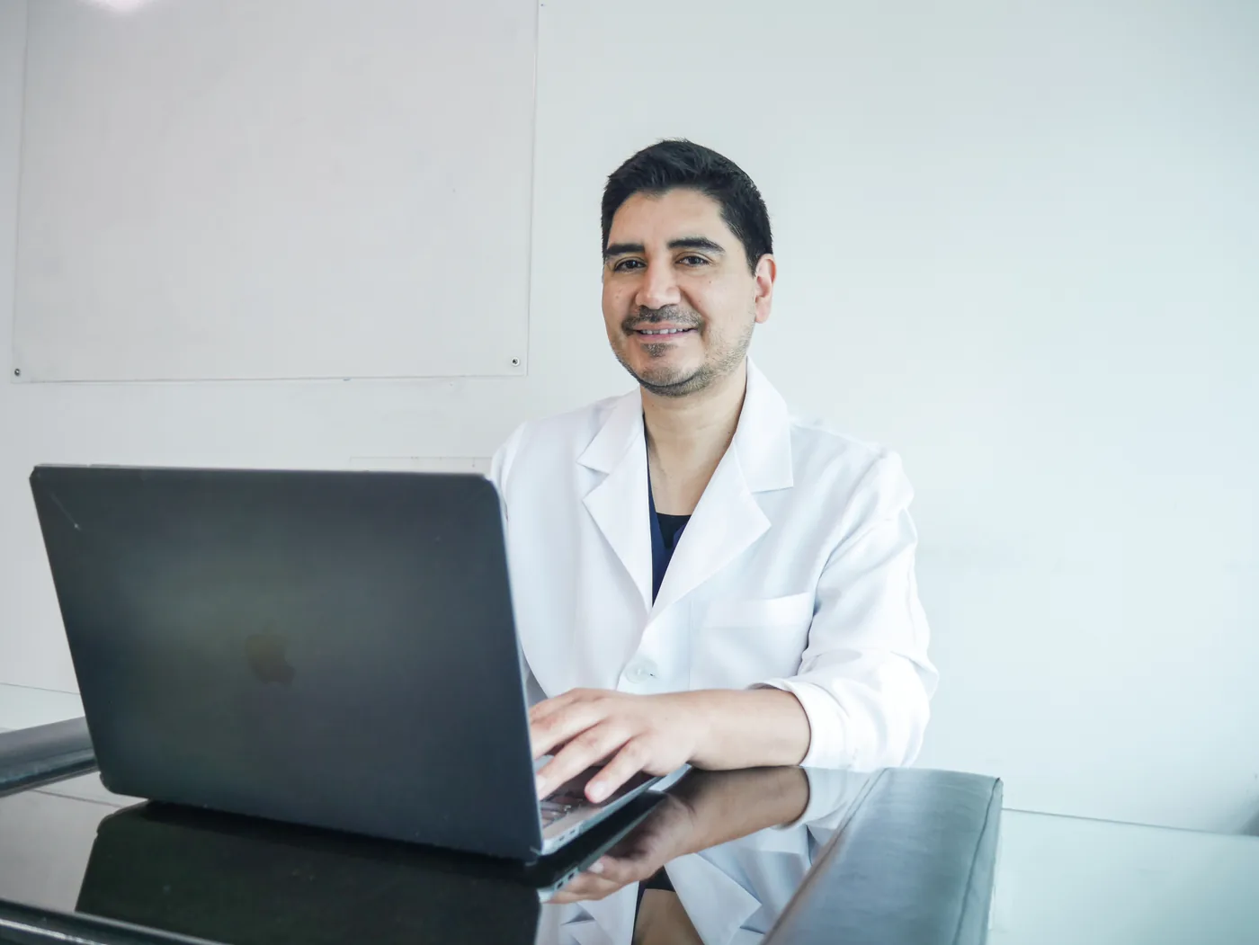 Dr. Luis Schwarz revisando expedientes médicos y teleconsultas en su estación digital